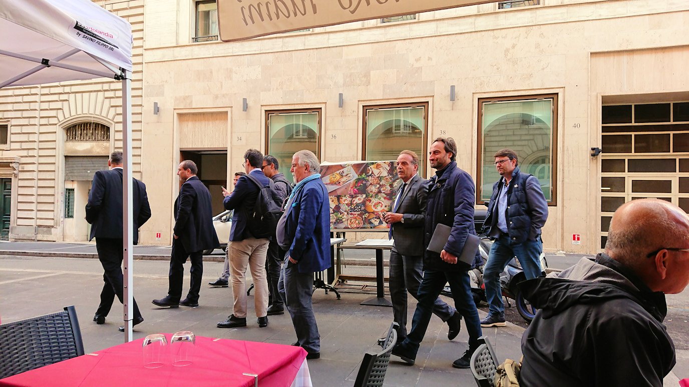ローマ市内でバスを降りてピザ屋さんの前を通る人達