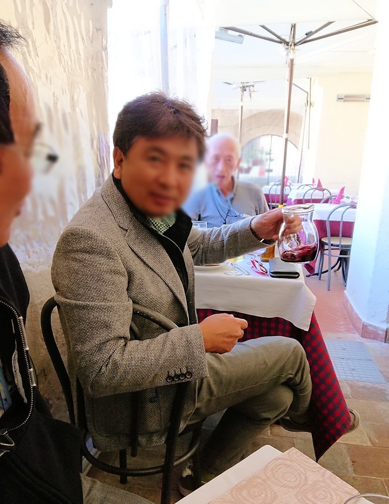 マテーラの街のヴィットリオ・ヴェネト広場にあるレストランでワインを味わう弁護士オジサン