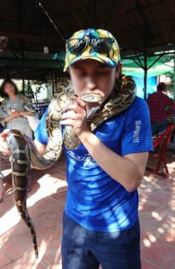 メコン川クルーズの島で蛇の首巻を体験する岡ちゃん