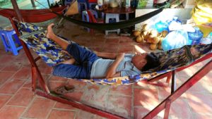 メコン川クルーズの島でハンモックで寝ている人