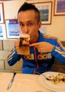 ナポリの街のレストランのビールを飲む男
