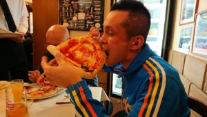 ナポリの街のレストランで美味しいピザを食べる男