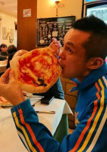 ナポリの街のレストランで美味しいピザを食べる男2