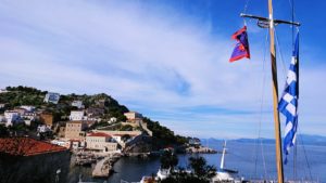 エーゲ海のイドラ島の高台になびくギリシャ国旗を見る2