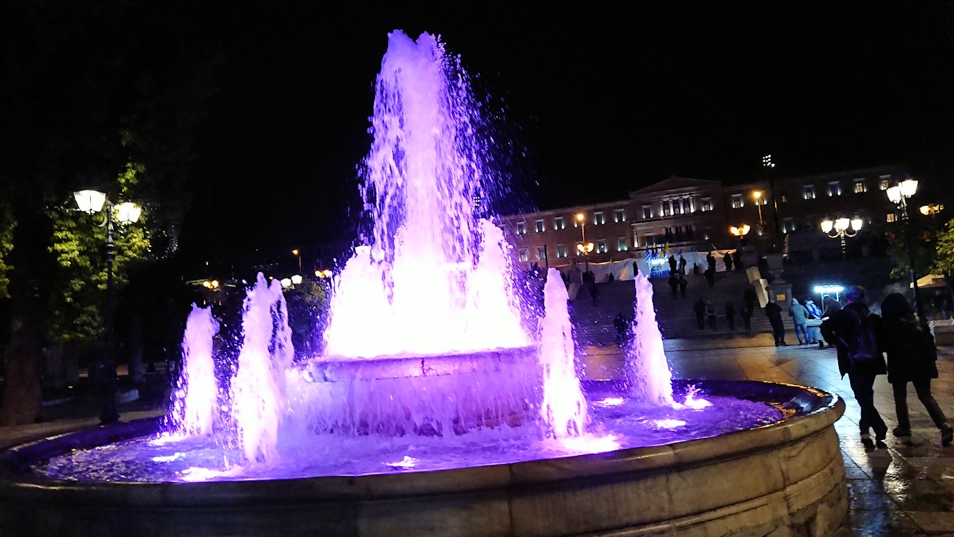 アテネの夜にシンタグマ広場付近で光る噴水に見とれる2
