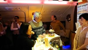 ドバイ国際空港から関西国際空港に向けて飛んでいる飛行機の機内ラウンジで盛り上がる8