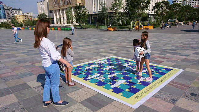 アルバニアで首都ティラナのスカンデルベグ広場ですごろくで遊ぶ子を4