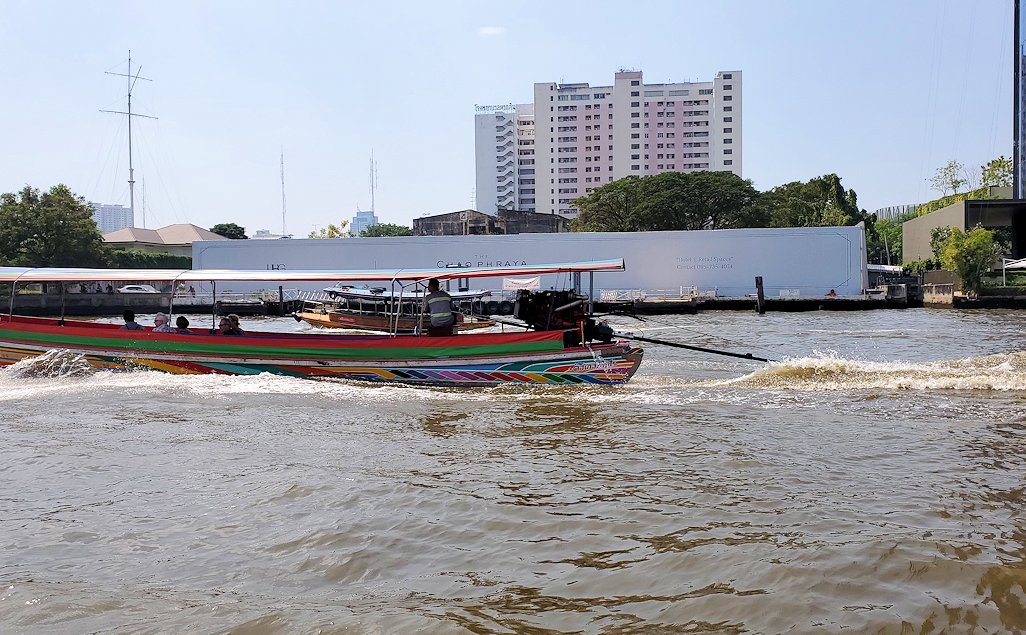 バンコク市内を流れるチャオプラヤー川を走る、車のエンジンを搭載した船の景色