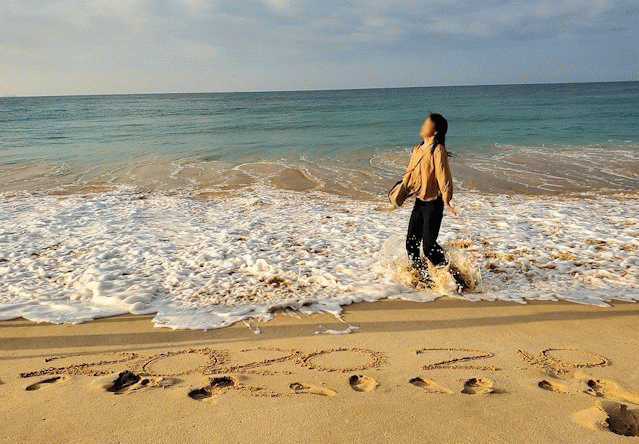 「ロング・ビーチ・リゾートホテル」のビーチからインド洋をバックに記念撮影するお姉さん-2