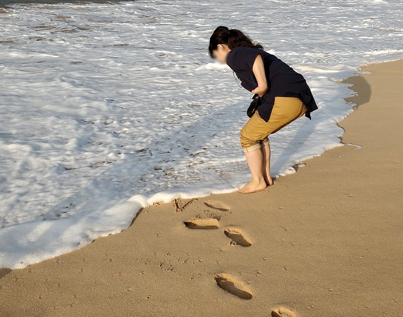 「ロング・ビーチ・リゾートホテル」のビーチで砂浜に文字を書くお姉さん-2